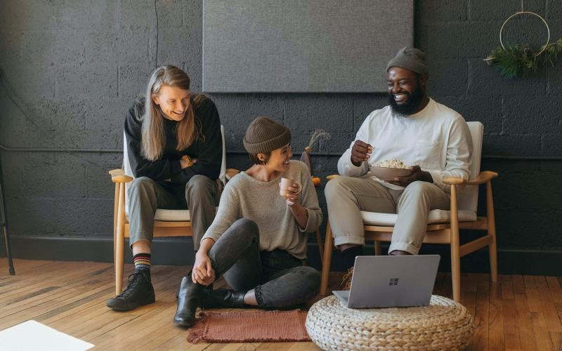 friends sit together around an open laptop